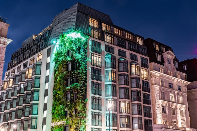 The outside of The Athenaeum Hotel & Residences with a view of its Living Wall and rooftop lounge